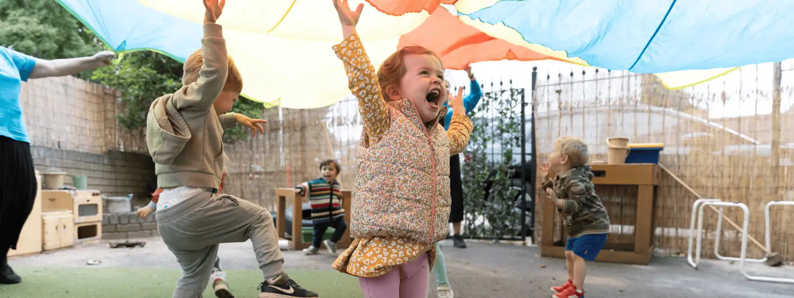 Happy children playing outdoors at Monkey Puzzle Day Nursery Sunbury.